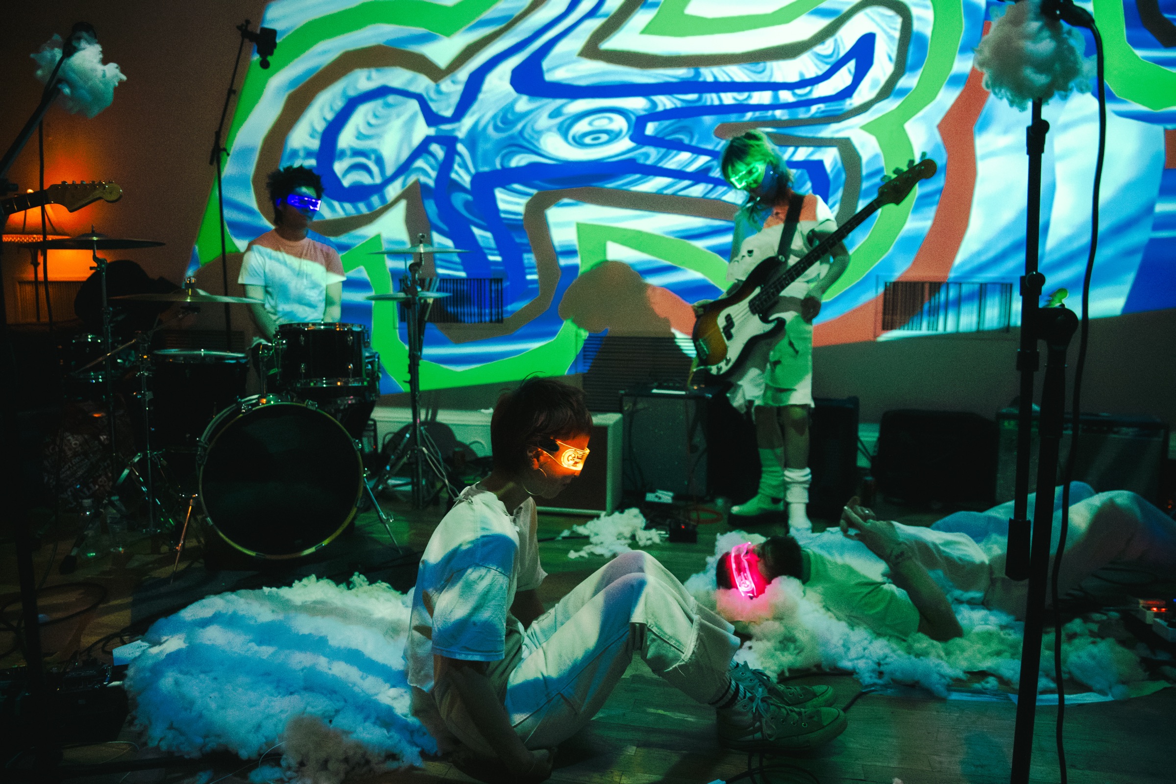 Live band performance with neon LED glasses and projected visuals